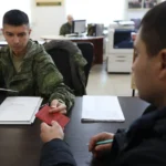 A volunteer submits his documents for military service