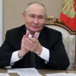 Russian President Vladimir Putin applauds