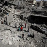 Palestinians inspect the site of an Israeli strike