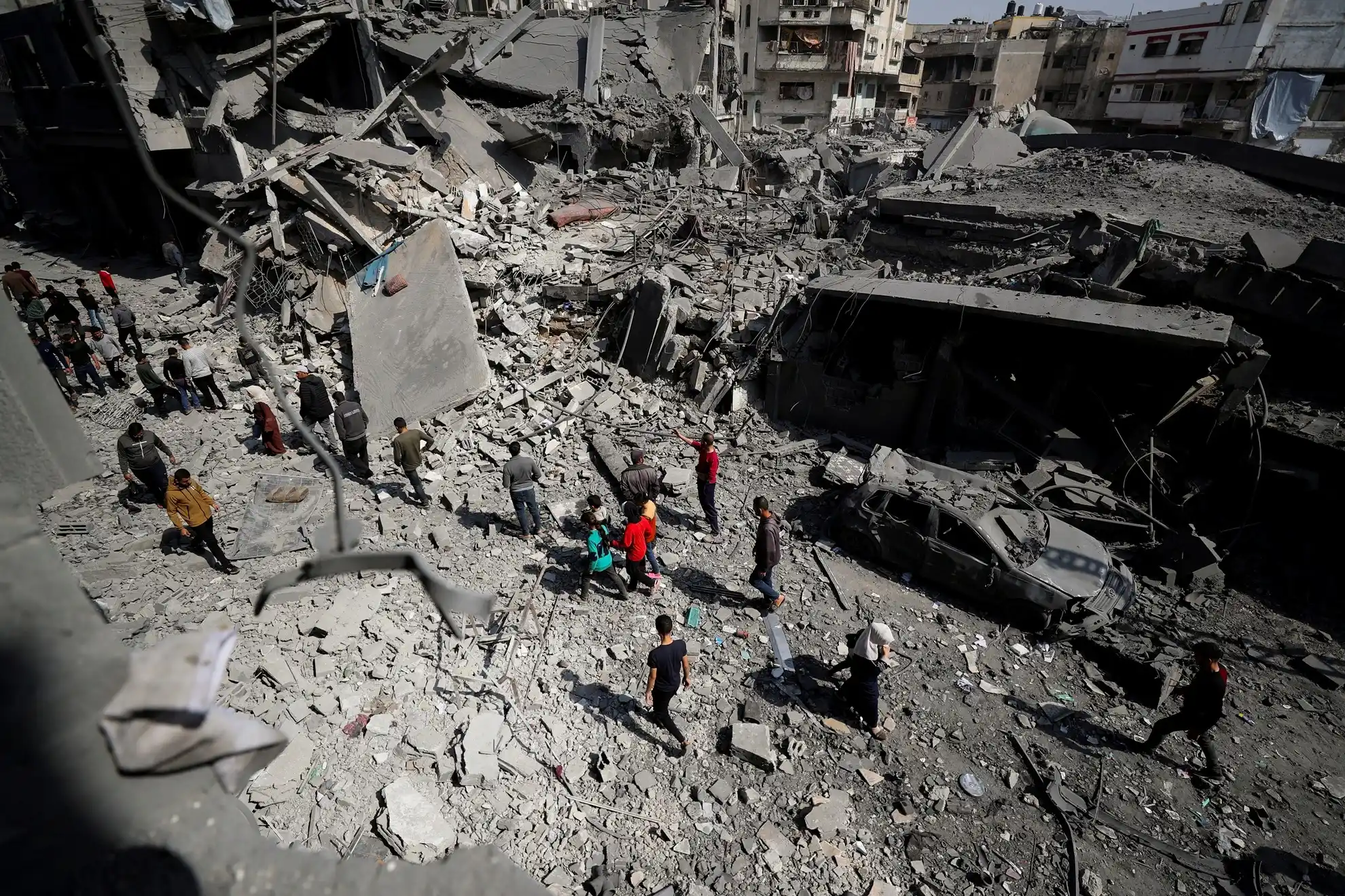 Palestinians inspect the site of an Israeli strike