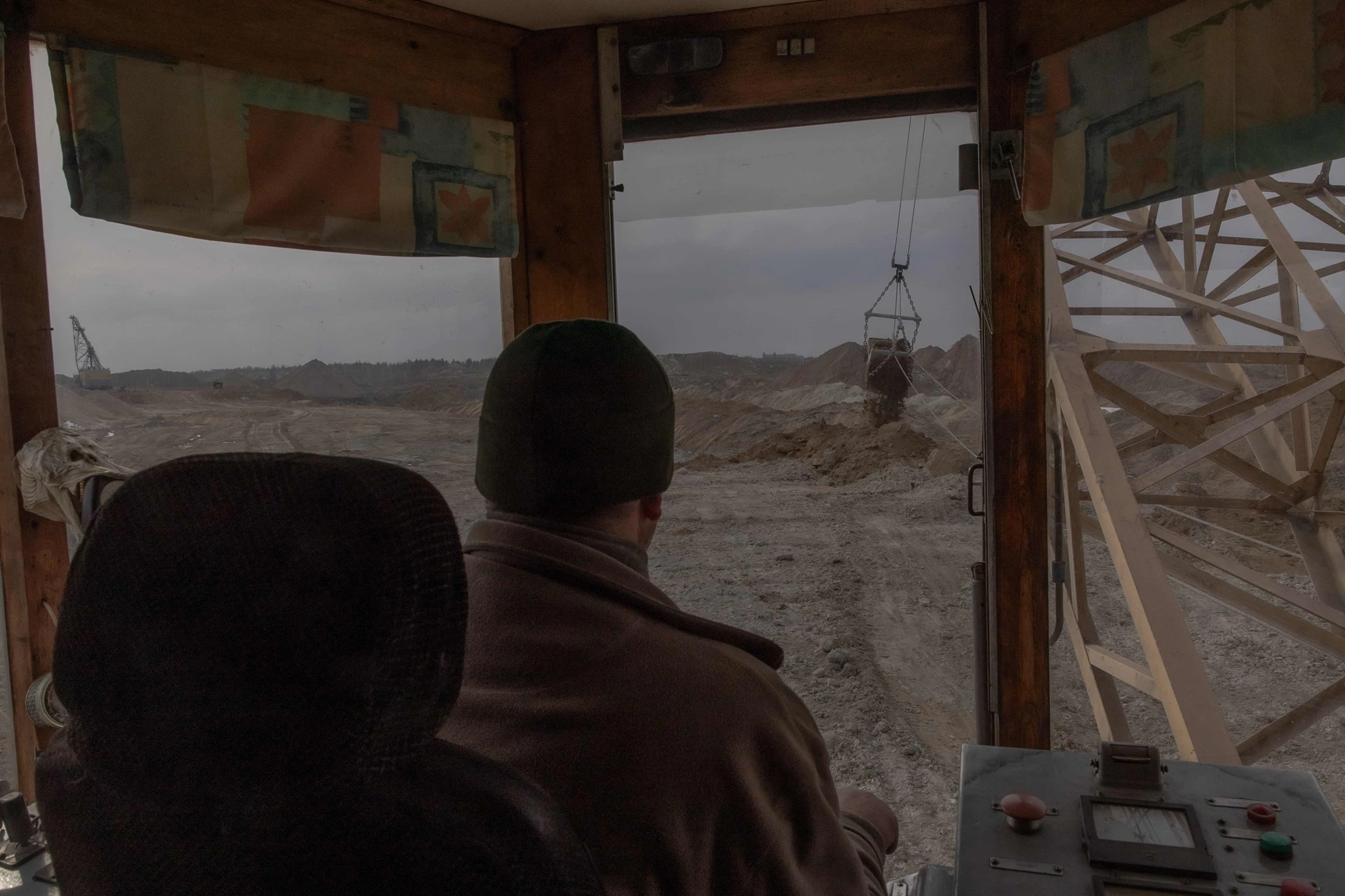 Рабочий управляет экскаватором-драглайном