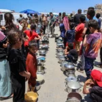 Palestinians line up to receive a hot meal
