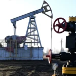 A view shows a pump jack at an oil field